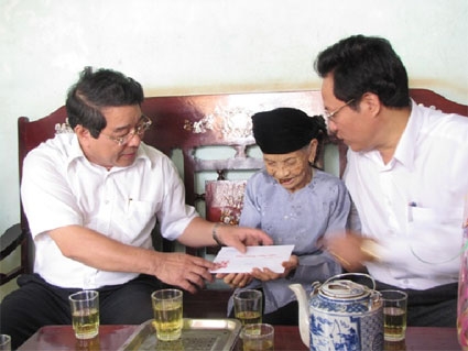 Ông[-]Trương[-]Tấn[-]Thiệu[-](trái)[-]trong[-]một[-]lần[-]đi[-]trao[-]quà.[-]Ảnh:[-]Báo[-]Bình[-]Phước.